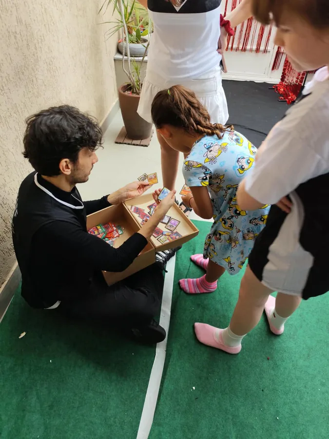 Recreador distribuindo figurinhas e brindes para as crianças